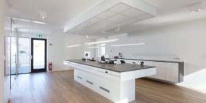 Modern tandtechnisch laboratorium met maatwerk werktafels en witte kasten