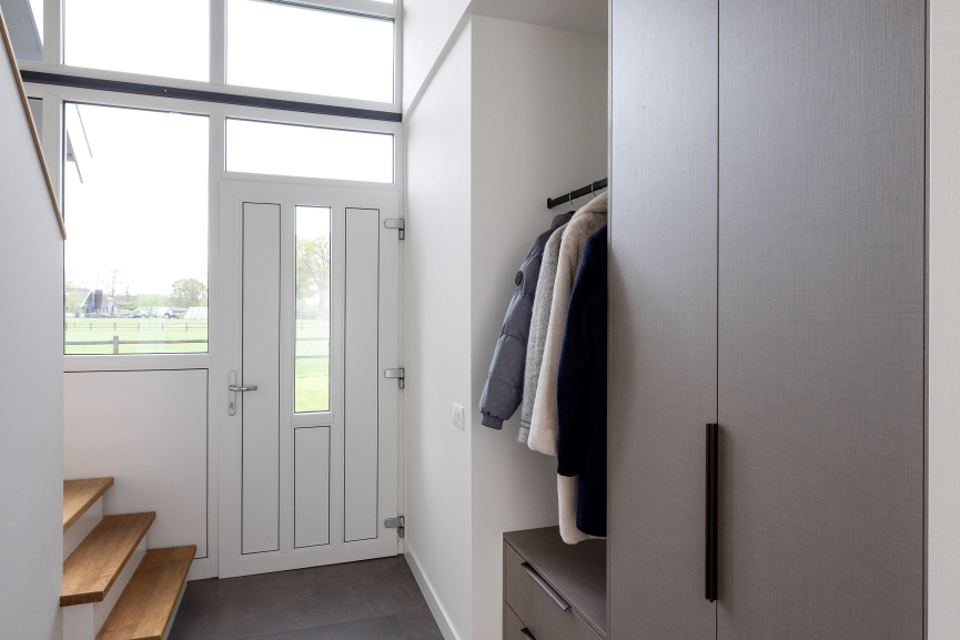 Maatwerk garderobe in hal met geïntegreerde opbergruimte – Thomas Bos Interieurbouw.