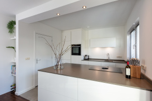 Minimalistische maatwerkkeuken met hoogglans witte fronten en Scandinavische uitstraling, gerealiseerd door Thomas Bos Interieurbouw.