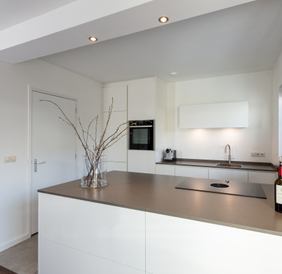 Minimalistische maatwerkkeuken met hoogglans witte fronten en Scandinavische uitstraling, gerealiseerd door Thomas Bos Interieurbouw.