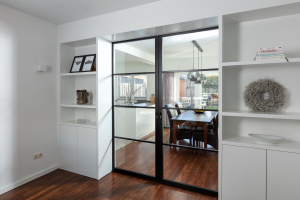 Industriële stalen ensuite-deuren met glas en ingebouwde witte kasten, op maat gemaakt door Thomas Bos Interieurbouw.