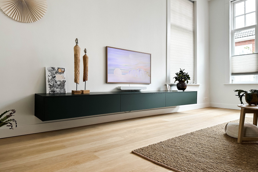 Zwevend donkergroen televisiemeubel in moderne minimalistische woonkamer